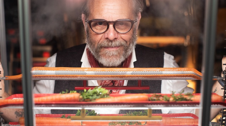 Alton Brown looking through an oven