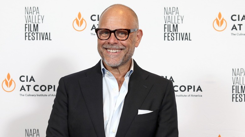 Alton Brown smiling, wearing black blazer
