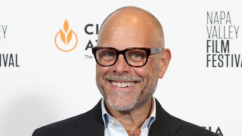 Alton Brown smiles at an industry event red carpet