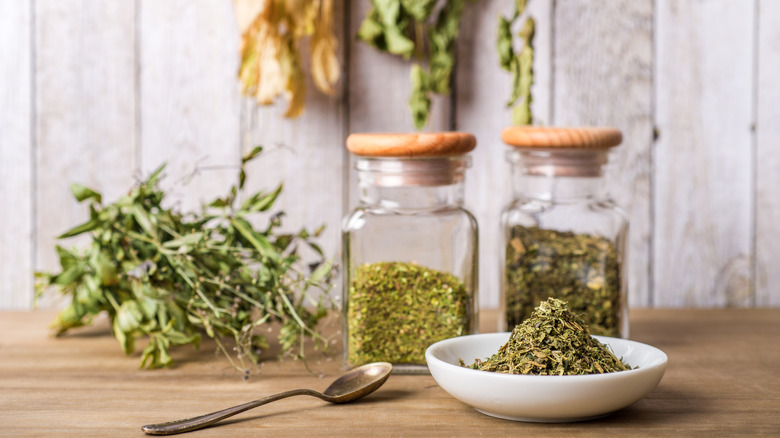 Bottles and bowl of dried herbs