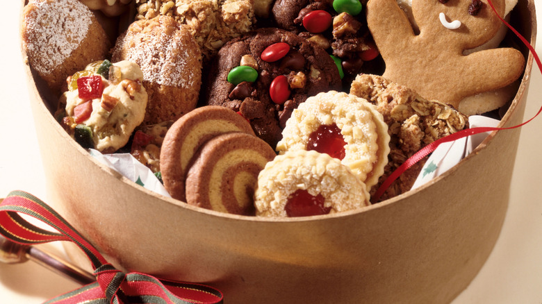 Holiday cookies including gingerbread men all together in a tin.