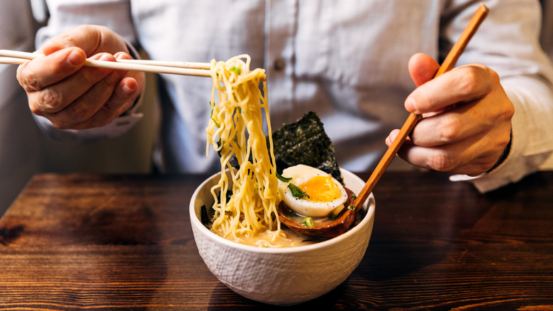 Person eating ramen with chopsticks