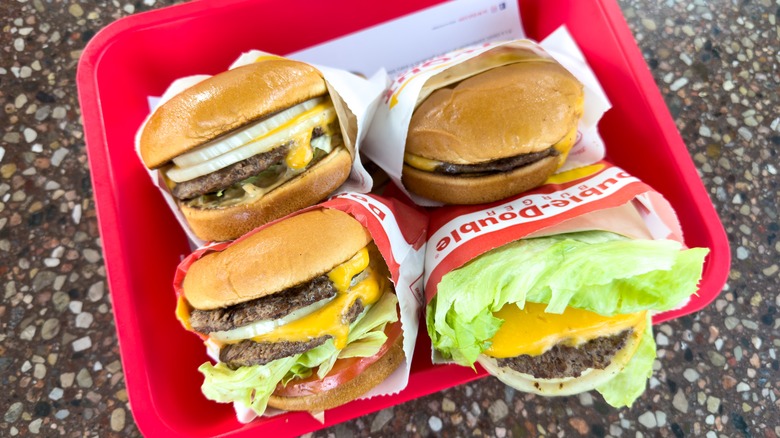 Four In-N-Out burgers in a red tray.