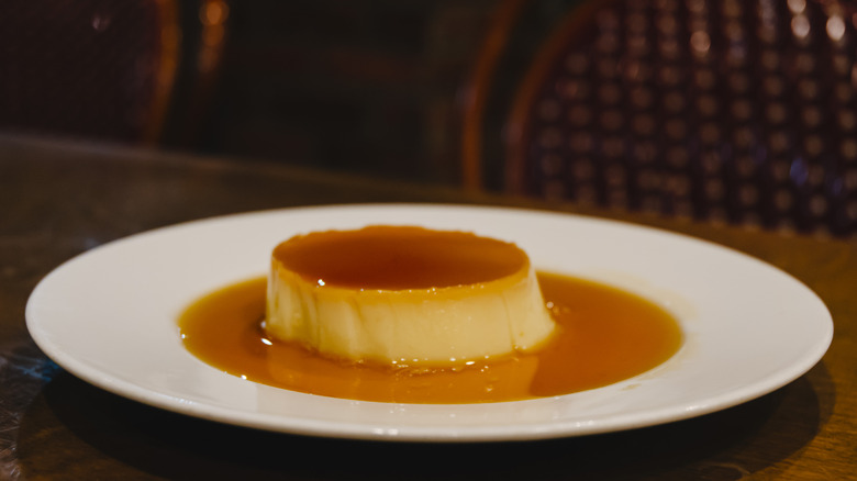 Crème caramel dessert on a wooden table.