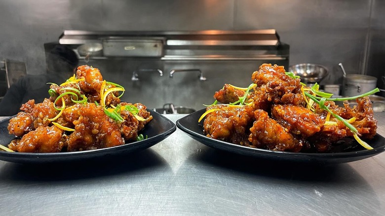 Plates of orange chicken on the kitchen line counter at Night & Market in Los Angeles