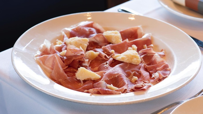 A plate of sliced prosciutto with chunks of Parmigiano Reggiano from Osteria Mozza in Los Angeles