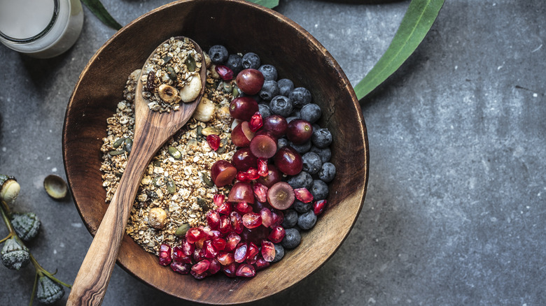 A healthy gluten-free breakfast cereal with berries in a wooden bowl.