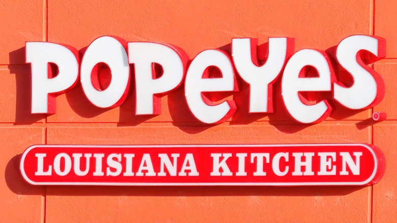 Storefront Popeyes sign on orange wall