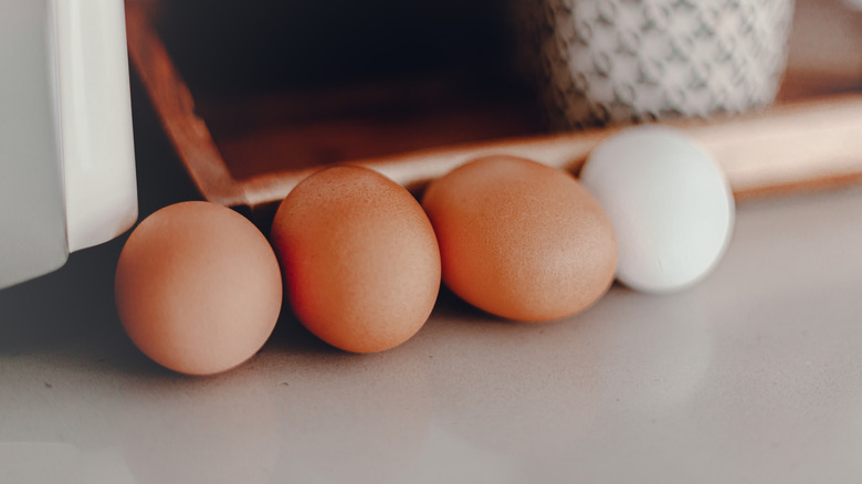 Brown and white eggs resting on kitchen counter