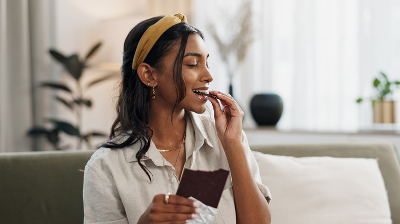 Woman savoring a piece of chocolate