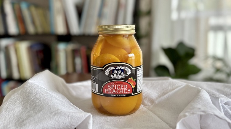Amish Wedding Spiced Peach Halves on table in front of shelf