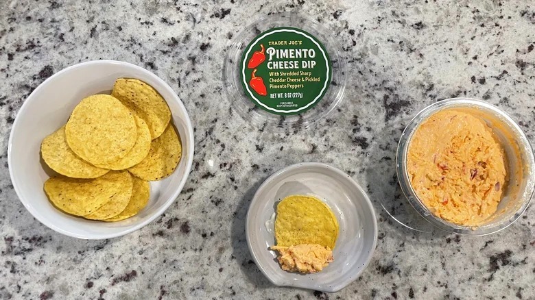 Trader Joe's Pimento cheese dip next to chips on a marble countertop