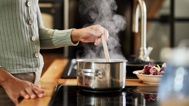 Person stirring steaming pot
