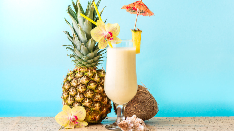 Piña colada with umbrella, pineapple, and coconut