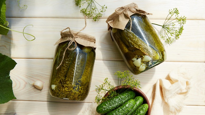 Jars of pickles next to herbs