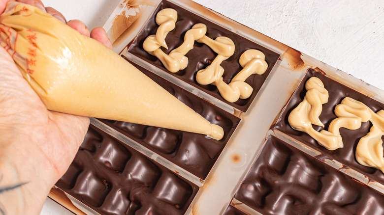 Filling a chocolate mold with Baileys cream