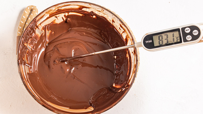 Melted chocolate in a bowl with a thermometer showing 83F