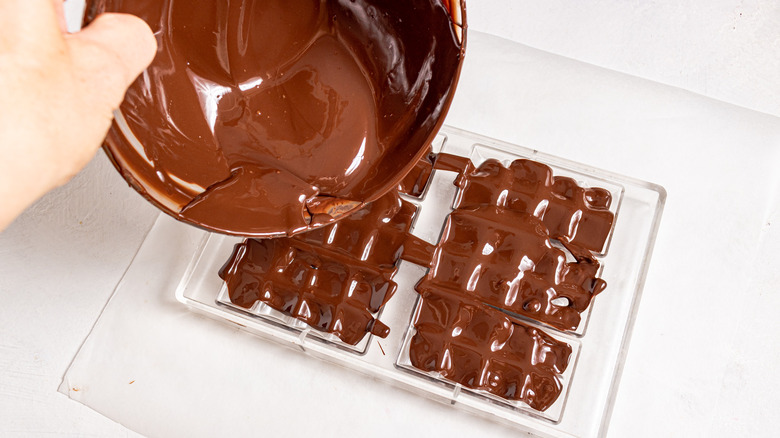 Filling a chocolate mold with melted chocolate