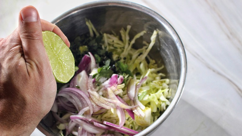 squeezing lime into bowl of slaw