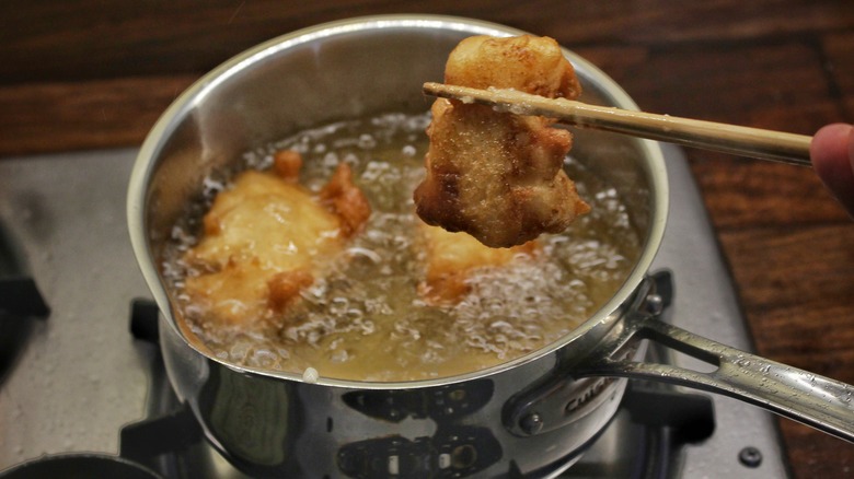 fried fish coming out of pot