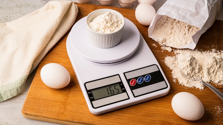 White digital kitchen scale weighing a ramekin of flour