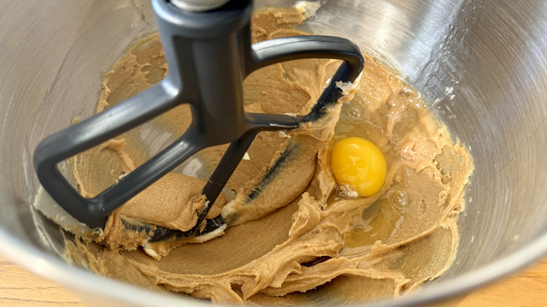 An egg and dough in a stand mixer