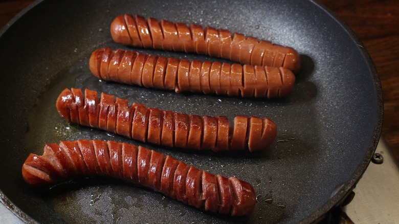 spiral cut hot dogs frying in skillet