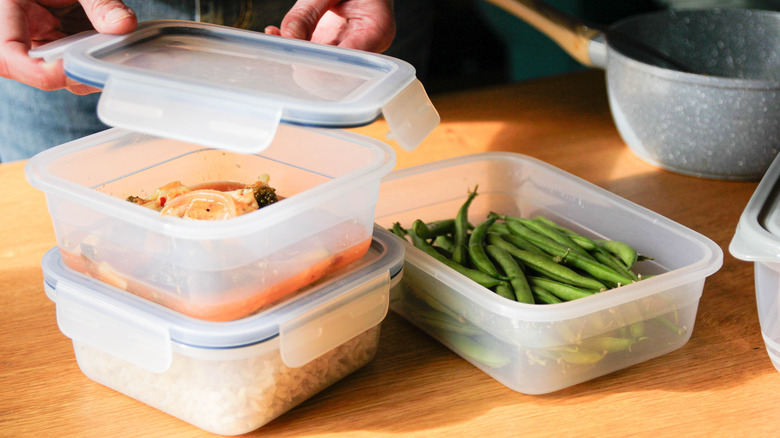 Three plastic food containers with leftovers