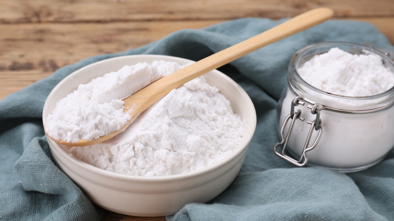 Cornstarch in white bowl with wooden spoon