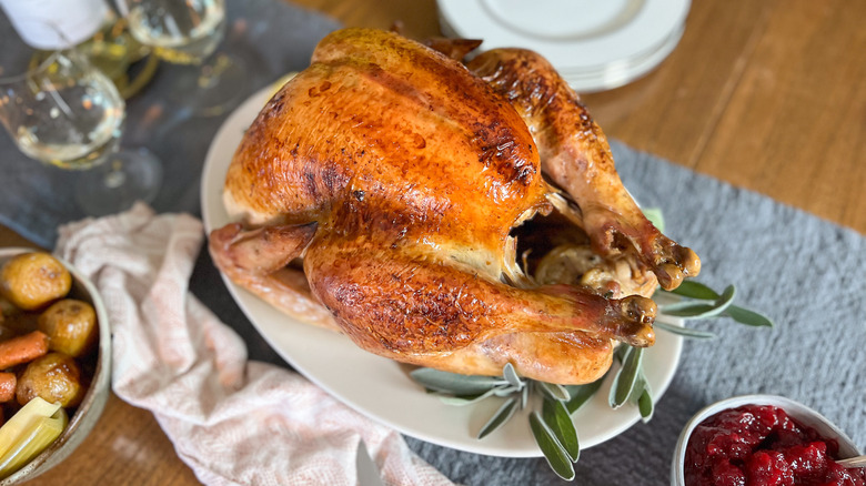 Basic roasted turkey on platter on table with wine
