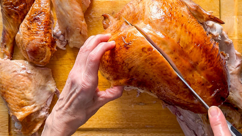Carving a basic roasted turkey on a cutting board