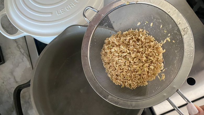 adding rinsed rice to pot