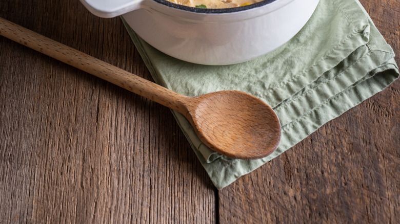 A pot of white chicken chili dotted with corn and herbs.