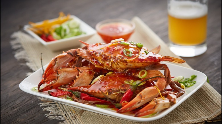 Two whole, cooked crabs with glass of beer