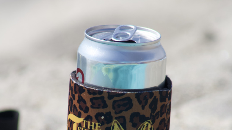 beer in a koozie on the beach