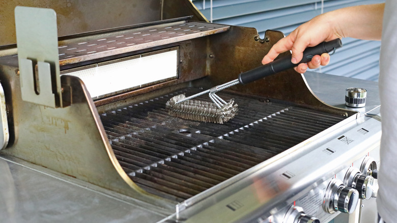 Cleaning outdoor grill with brush