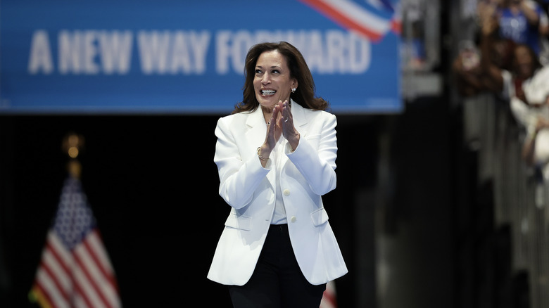 Kamala Harris smiling and clapping while walking