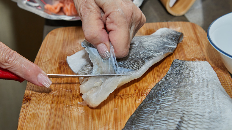 Chef skinning a fish
