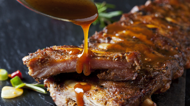 Barbecue sauce pouring onto pork ribs