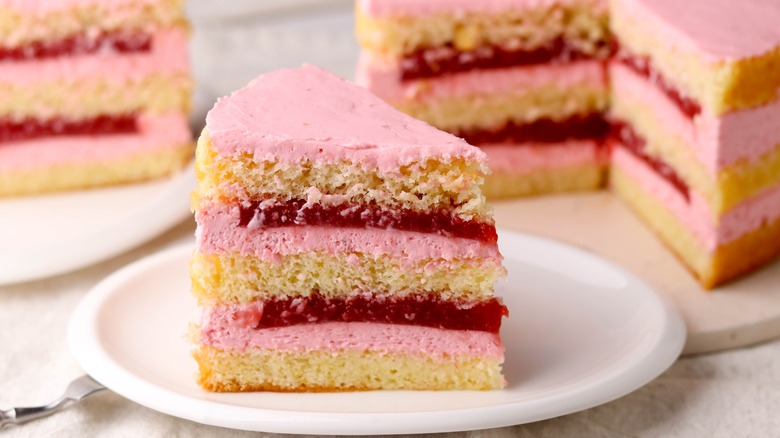 Tiered fruit-filled cake slice with pink frosting