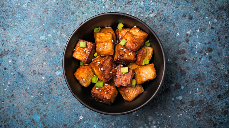 Crispy marinated tofu and green onions in bowl