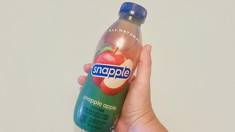 Hand holding Snapple Apple Juice