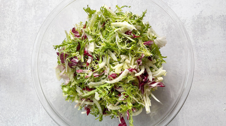 Frisee, radicchio, endive, and fennel in large glass bowl