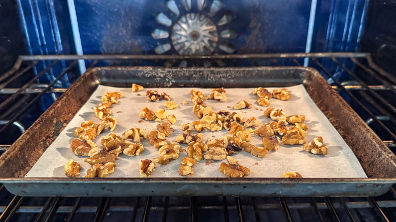 Walnuts toasting on baking sheet in oven