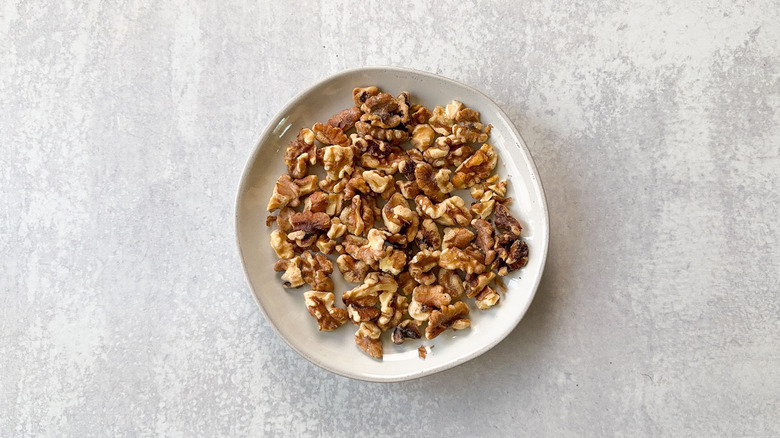 Toasted walnut halves and pieces on plate