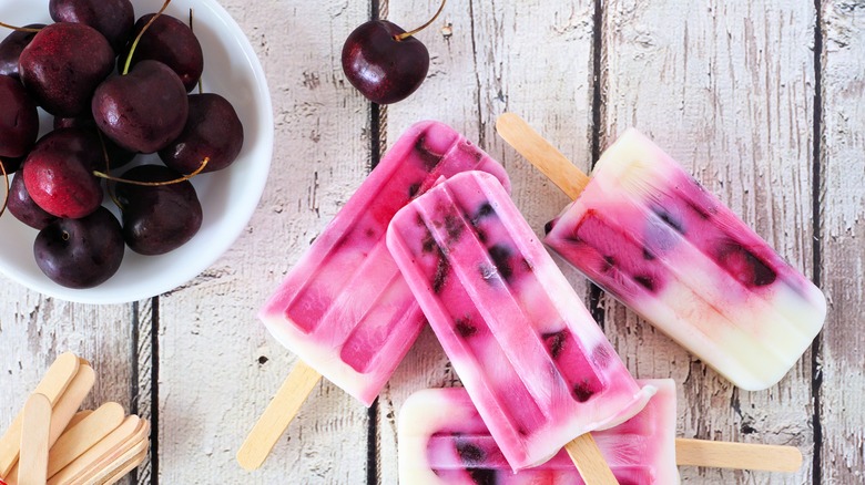 Cherries and popsicles on wooden counter