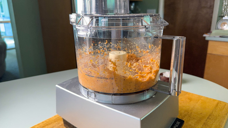 Pureed salmon and seasonings in food processor on countertop