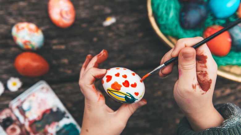 Child painting a white egg