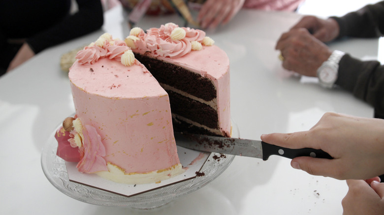 Person cutting into a cake with a knife