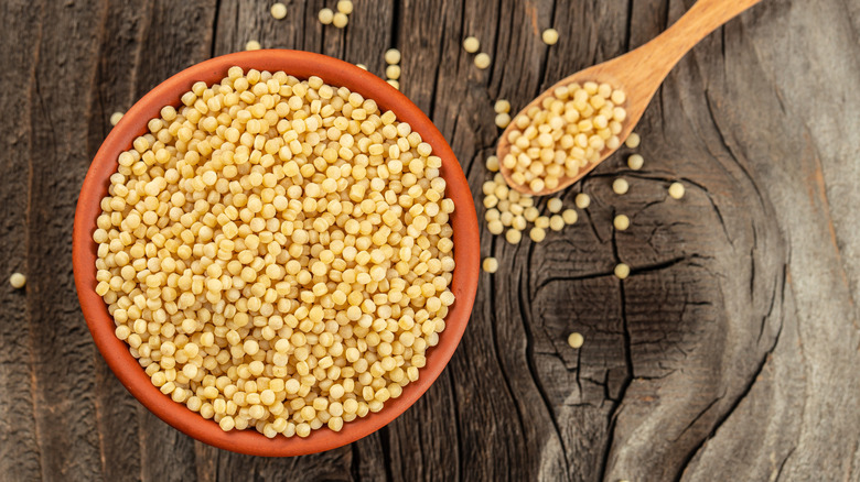 dry pearl couscous in bowl with spoon